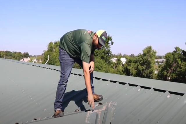 Meridian Roofing worker checking on metal roof seam